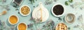 A white porcelain teapot, two cups, suga and assortment of dry tea in white ceramic bowls on blue background Royalty Free Stock Photo