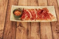 A white porcelain tray with a lid of Iberian ham cut into thin slices and with some grated tomato Royalty Free Stock Photo