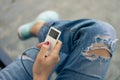 White portable music player in hand with red nail polish