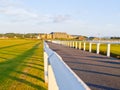 White post and rail wooden fences lining road leading to historic clubhouse