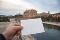 White postcard mockup in man`s hand on the background Catedral de Mallorca in Palma town on Mallorca Island in Spain Royalty Free Stock Photo