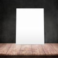 White poster on a wooden table with concrete wall background Royalty Free Stock Photo