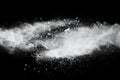 White powder explosion cloud against black background.White dust particles splash