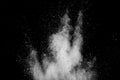 White powder explosion on black background. White dust particles splash