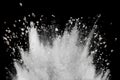 White powder with small stones explosion on black background.