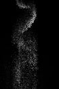 White powder splash isolated on black background. Flour sifting on a black background. Explosive powder white flour