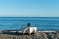 White powerboat with paddles waiting on the pebble beach with the calm sea water surface background. Summer vacation at sea. Water Royalty Free Stock Photo