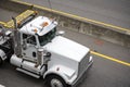 White powerful big rig semi truck with oversize load sign on the roof running on the highway road to point of loading oversized Royalty Free Stock Photo