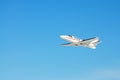 A white private plane flies in blue sky Royalty Free Stock Photo