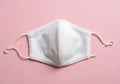 White Protective Face Mask on Pink Background Royalty Free Stock Photo