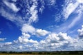 White puffy clouds in blue sky, agricultural landscape Royalty Free Stock Photo