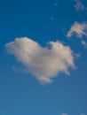 White puffy heart shaped cloud set against a deep blue summer sky Royalty Free Stock Photo