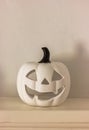 white pumpkin figure of candle holder jack-o-lantern on a shelf. Home decor for Halloween Royalty Free Stock Photo