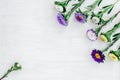 White and purple asters on white wooden background