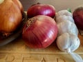 White and purple onions and garlic cloves on woden cutting board Royalty Free Stock Photo