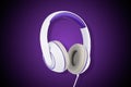 White and purple padded headphones isolated on purple