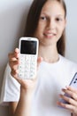 White push-button telephone in the hand of a girl with a smartphone vertical view