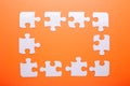 White puzzle on orange background. Top view Royalty Free Stock Photo