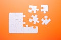 White puzzle on orange background. Top view Royalty Free Stock Photo