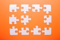 White puzzle on orange background. Top view Royalty Free Stock Photo