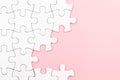 White puzzle over pink backround with missing pieces. Incomplete elements, solution search concept Royalty Free Stock Photo