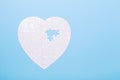 White puzzle in shape of heart on blue background Jigsaw Concept treatment of heart disease pills Royalty Free Stock Photo