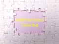 White puzzle with the word Artificial Food Coloring on a pink background