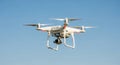 White Quadcopter Drone with Camera Flying in Clear Blue Sky Royalty Free Stock Photo