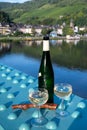 White quality riesling wine served on old bridge across Mosel river with view on old German town in sunny day