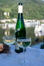 White quality riesling wine served on old bridge across Mosel river with view on old German town in sunny day