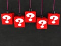 White question marks on red hanging toy blocks on black Royalty Free Stock Photo