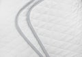 White quilted fabric. The texture of a blanket or bedspread