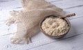 White quinoa flakes in clay bowl on table