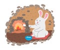 White rabbit grilling marshmallows on fire in his cosy burrow Royalty Free Stock Photo