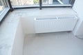 White radiator heating with thermostat for energy saving in the unfinished modern empty flat room.
