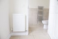 White radiator on wall and ensuite bathroom WC toilet Royalty Free Stock Photo