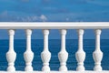 White railings with balusters on embankment against background of blue sea and sky, selective focus Royalty Free Stock Photo