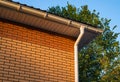 White rain gutter on the roof the brick building