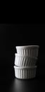 White ramekins stacked on black background with copy space Royalty Free Stock Photo