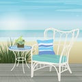 White rattan chair and mosaic table on a deck by the beach