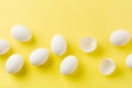 White raw chicken eggs lying in horizontal row with broken egg on yellow background Royalty Free Stock Photo