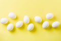 White raw chicken eggs lying in horizontal row with broken egg on yellow background. Top view Royalty Free Stock Photo