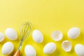 White raw chicken eggs lying in horizontal row with broken egg on yellow background. Royalty Free Stock Photo