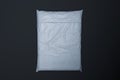 White realistic packet in transparent wrapping on black background. 3d rendering