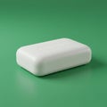 A white, rectangular bar of soap with rounded edges is placed on a solid green surface. Royalty Free Stock Photo