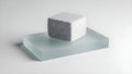 A white rectangular block of porous material sits on a light blue reflective surface against a plain background Royalty Free Stock Photo