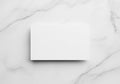 A white rectangular card is placed on a smooth, white marble Royalty Free Stock Photo