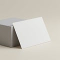 White rectangular card propped against a light gray cube on a neutral background. Th Royalty Free Stock Photo