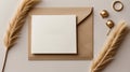 White rectangular card rests atop a beige envelope on a light surface. Flanking the card are two fluffy pampas grass stems Royalty Free Stock Photo