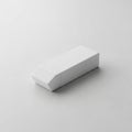 Rectangular eraser with a slightly tapered end sits on a smooth white Royalty Free Stock Photo